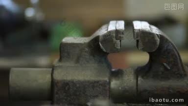 陈旧生锈的台钳在金属加工车间工人手中使用台钳